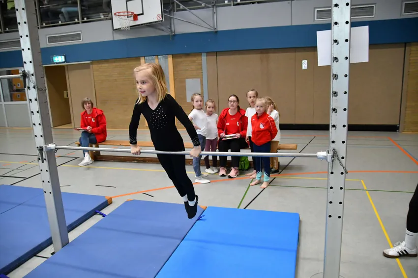  Am schulterhohen Reck in den Stütz springen und eine Rolle turnen.
